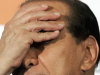 FILE - In this Oct. 6, 2005 file photo, Italian Premier Silvio Berlusconi touches his face during a joined press conference in Rome. Premier Silvio Berlusconi resigned in Rome, Saturday, Nov. 12, 2011, after the Parliament's lower chamber passed European-demanded reforms, ending a 17-year political era and setting in motion a transition aimed at bringing Italy back from the brink of economic crisis. The 75-year-old billionaire media mogul, who came to power for the first time in 1994 using a soccer chant "Go Italy" as the name of his political party, became Italy's longest-serving post-war premier. (AP Photo/Pier Paolo Cito , File)