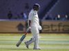 India's Dhoni walks from the field after being bowled by Australia's Pattinson during the first cricket test match in Melbourne