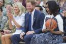 US First Lady Michelle Obama (R) reacts to catching a basketball alongside Britain's Prince Harry (C) and Jill Biden, wife of US Vice President, as they attend Wounded Warriors wheelchair basketball game at Fort Belvoir, Virginia, October 28, 2015