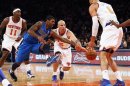 Dallas Mavericks' Mayo and New York Knicks' Kidd fight for a loose ball in front of Chandler during their NBA basketball game at Madison Square Garden in New York