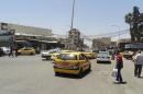 Vehicles drive on a street in the city of Mosul