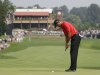 Tiger Woods taps in his par putt on the first hole during the final round of the Bridgestone Invitational golf tournament at Firestone Country Club in Akron, Ohio, Sunday, Aug. 7, 2011. (AP Photo/Mark Duncan)