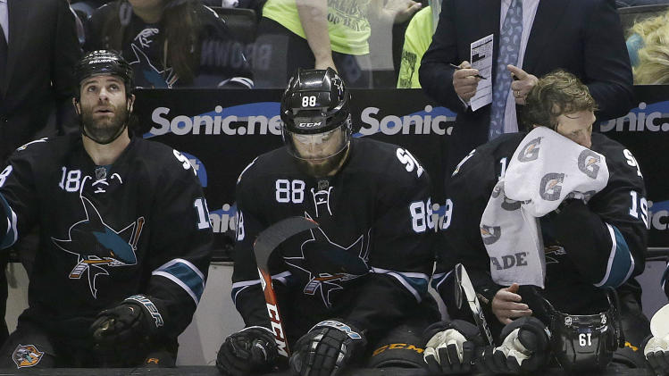 San Jose Sharks right wing Mike Brown, from left, defenseman Brent Burns, and center Joe Thornton sit on the bench during the third period of Game 7 of an NHL hockey first-round playoff series against the Los Angeles Kings in San Jose, Calif., Wednesday, April 30, 2014. The Kings won 5-1. (AP Photo)