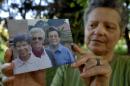 Silvia Marsili, an official of Saverian missionaries' head convent in Parma, Italy, shows a photo of the three Italian missionary nuns, from left, Bernardetta Boggian, Olga Raschietti and Lucia Pulici, found slain in their convent in Burundi, Monday, Sept. 8, 2014. The Italian foreign ministry confirmed the slayings in Kamenge, near Bujumbura, Burundi's capital. Pope Francis, in a condolence telegram to Bujumbura's archbishop, said he "learned with great sadness of the murder" of the three "faithful and devout nuns in these tragic circumstances." (AP Photo/Marco Vasini).