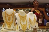 A saleswoman displays a gold necklace at a jewellery showroom in Kolkata August 1, 2011. REUTERS/Rupak De Chowdhuri/Files