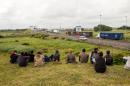 Migrants sit near the A16 highway as they try to access the Channel Tunnel on June 23, 2015 in Calais, northern France