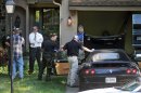 In this July 15, 2013, photo authorities search a vehicle at the home of Anthony Garcia near Terre Haute Ind. Garcia, an Indiana doctor who was fired from a Nebraska medical school more than a decade ago, was arrested Monday during a traffic stop in Illinois on suspicion of killing four people with ties to the school in two separate attacks five years apart. (AP Photo/Tribune-Star, Bob Poynter)