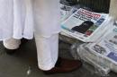 A man looks at newspapers outside the Brick Lane Jamme Masjid before Friday prayers in east London