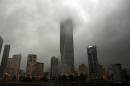 Clouds cover buildings in Kuwait City during a heavy rainfall on November 18, 2013