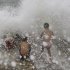 Filipino boys play amid strong waves at Manila bay, Philippines, Sunday, Aug. 28, 2011. Slow-moving Typhoon Nanmadol remained dangerous Sunday despite weakening as it struck the tip of the mountainous northern Philippines. (AP Photo/Aaron Favila)