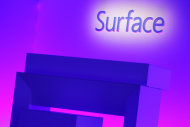 The Surface logo is illuminated on a stage prior to the introduction Microsoft's new Surface tablet computer, Monday, Sept. 23, 2013 in New York. Microsoft is introducing new Surface tablet computers and accessories, including a professional model that allows people to use it more like a laptop or a desktop. (AP Photo/Mark Lennihan)