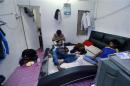 Rohingya men rest in a rented house in Cheras Baru, Kuala Lumpur