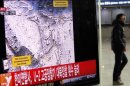 A passenger walks past a television report on North Korea's nuclear test at a railway station in Seoul