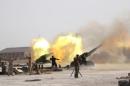 Iraqi security forces and Shi'ite fighters fire artillery towards Islamic State militants near Falluja