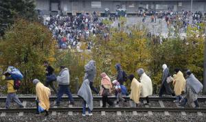 Migrants walk on train tracks after leaving a camp,&nbsp;&hellip;