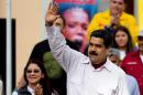 Venezuelan President Nicolas Maduro (R) greets supporters next to First Lady Cilia Flores during a rally in Caracas on June 14, 2016