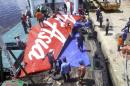 A section of AirAsia flight QZ8501's tail is loaded onto a boat for transportation to Jakarta from Kumai Port, near Pangkalan Bun, Central Kalimantan