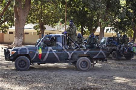 Malian soldiers drive a pickup truck past other vehicles stationed in Niono January 19, 2013. REUTERS/Joe Penney