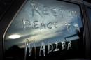 A message using Nelson Mandela's clan name "Madiba" and a term of affection "Tata" meaning "father", is scrawled on the window of a car parked in the street outside Mandela's old house in Soweto, Johannesburg, South Africa Friday, Dec. 6, 2013. South Africans of all races often referred to Nelson Mandela as simply "Madiba" or "Tata", terms of endearment that promoted a sense of familiarity for a towering figure who was widely revered. (AP Photo/Ben Curtis)