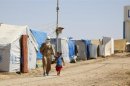 Syrian refugees walk at the Domiz refugee camp in the northern Iraqi of province Dohuk