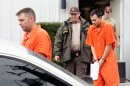 FILE - In this Dec. 12, 2011 file photo, U.S. Army Sgt. Anthony Peden, 25, left, and Pvt. Isaac Aguigui, 19, are led away in handcuffs after appearing before a magistrate judge at the Long County Sheriffs Office in Ludowici, Ga. Prosecutors say a murder case against the four soldiers in Georgia has revealed they formed an anarchist militia within the U.S. military with plans to overthrow the federal government, The Associated Press reports Monday, Aug. 27, 2012. (AP Photo/Lewis Levine, File)