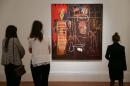 Visitors look at a painting owned by late British singer David Bowie, named 'Air Power' by US artist Jean-Michel Basquiat executed in 1984 with an estimated price of 2.5-3.5 million GBP at Sotheby's auction house in London