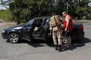 A Ukrainian serviceman checks a car at a checkpoint …