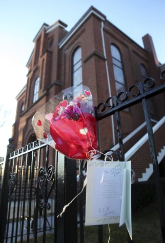 In this file photo of Sunday, Feb. 12, 2012, flowers and a card hang on a fence in front of New Hope Baptist Church in Newark, N.J. Whitney Houston's funeral will be held Saturday, Feb. 18 at the church where she sang in the choir as a girl. Houston, who ruled as pop music's queen until her majestic voice and regal image were ravaged by drug use, erratic behavior and a tumultuous marriage to singer Bobby Brown, died Saturday. She was 48. (AP Photo/Mel Evans, file)