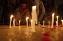 A man lights candles to mourn the victims from the Army Public School in Peshawar, which was attack by Taliban gunmen, in Karachi