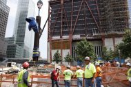 The September 11 cross is lowered by crane into a subterranean section of the National September 11 Memorial and Museum, Saturday, July 23, 2011 in New York. The cross was discovered upright in the ruins of ground zero following the attacks of September 11, 2001. (AP Photo/Mark Lennihan, Pool)