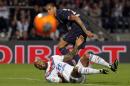 Lyon's Jimmy Briand, down, challenges for the ball with Paris Saint Germain's Gregory Van Der Wiel, up, during their French League One soccer match in Lyon, central France, Sunday, April 13, 2014. (AP Photo/Laurent Cipriani)