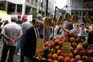 <p>               A street vegetable vendor discusses Greece's crisis with a man  as in the background is seen a protest outside the ministry of Finance, in central Athens, on Wednesday, Sept. 12, 2012. A fresh wave of anti-austerity strikes hit Greece Wednesday as the leaders of the governing coalition struggled to finalize further spending cuts for the coming two years — without which the country will lose its vital rescue loans.(AP Photo/Petros Giannakouris)
