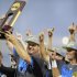UCLA coach John Savage is surrounded by players as he hoists the trophy after beating Mississippi State 8-0 in Game 2 of the NCAA College World Series baseball finals, Tuesday, June 25, 2013, in Omaha, Neb., winning the championship. (AP Photo/Eric Francis)