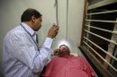 Vinay Kulkarni, a doctor, examines the eyes of a patient inside his clinic in Pune