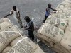 Workers prepare to load sacks of cocoa onto a ship at the port of Abidjan