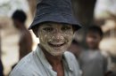 A Myanmar villager, with his face smeared with herbal paste, poses for a photograph in the village of Wah Thin Kha from where pro-democracy leader Aung San Suu Kyi is standing for by-elections in Myanmar, Thursday, March 29, 2012. (AP Photo/Altaf Qadri)