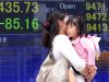 A woman and a child walk in front of the electronic stock board of a securities firm in Tokyo, Japan, Tuesday,  May 1, 2012. Japan's Nikkei 225 fell Tuesday amid a stronger yen and signs of a slowing U.S. economy, while other key Asian stock indexes were closed for a public holiday. (AP Photo/Itsuo Inouye)
