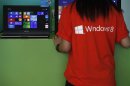 Attendant works checks a computer during launch of Microsoft Windows 8 in Hong Kong