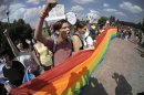 Gay rights activists shout slogans during their authorized rally in St.Petersburg, Russia, Saturday, June 29, 2013. Police detained several gay activists, who were outnumbered by the protesters. Dozens of gay activists had to be protected by police as they gathered for the parade, which proceeded with official approval despite recently passed legislation targeting gays. (AP Photo/Dmitry Lovetsky)
