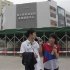 Foxconn employees eat ice creams during lunch break in front of the Foxconn recruitment center in Shenzhen