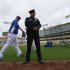 Los Angeles Dodgers starting pitcher Hyun-Jin Ryu, left, of South Korea, walks by a police officer during batting practice before their baseball game against the San Diego Padres, Monday, April 15, 2013, in Los Angeles. (AP Photo/Mark J. Terrill)