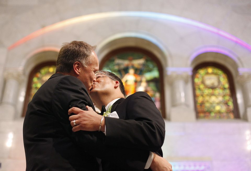 Jeff Isaacson, left, and Al Giraud, right, kiss for the first time as a married couple during the Minneapolis Freedom to Marry Celebration and Weddings at the Minneapolis City Hall, Thursday, Aug. 1, 2013. The two were the first men to be married legally in Minnesota. (AP Photo/Stacy Bengs)