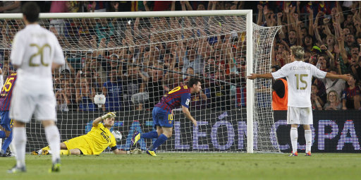 FC Barcelona's Lionel Messi from Argentina scores his goal, second right between Real Madrid's players during a second leg Spanish Supercup soccer match against Real Madrid at the Camp Nou stadium in Barcelona, Spain, Wednesday, Aug. 17, 2011. (AP Photo/Andres Kudacki)