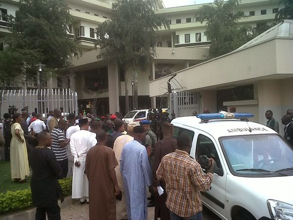 This image released by Saharareporters shows ambulances and rescue workers after a large explosion struck the United Nations' main office, background, in Nigeria's capital Abuja Friday Aug. 26, 2011, 