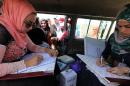 Iraqi medical staff work in a vehicle during a vaccination campaign against cholera at a makeshift camp housing displaced Iraqis who fled the violence in the Iraqi city of Ramadi, on the southern outskirts of Baghdad, on September 21, 2015