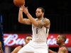 Brooklyn Nets' Deron Williams, center passes the ball in front of Portland Trail Blazers' Ronnie Price, right, in the third quarter of an NBA basketball game at the Barclays Center, Sunday, Nov. 25, 2012, in New York. The Nets won 98-85. (AP Photo/Henny Ray Abrams)