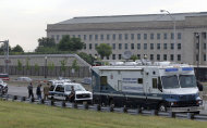 Law enforcement work near the Pentagon after a suspicious vehicle forced multiple road closures Friday, June 17, 2011 in Arlington, Va. Officials in Washington say one man is under arrest after they found his car, parked in the bushes near the Pentagon, contained material that appears to be ammonium nitrate. The vehicle also contained spent 9 mm shells and written materials stating "al Qaeda Taliban rules." (AP Photo/Alex Brandon)