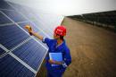 A worker inspects solar panels at a solar farm in Dunhuang