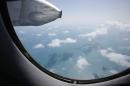 Clouds hover outside the window of an aircraft on a mission to find the missing Malaysia Airlines flight MH370, off Tho Chu island