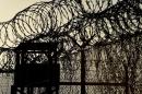 A picture taken April 09, 2014 and reviewed by the US military shows the razor wire-topped fence and a watch tower at the abandoned "Camp X-Ray" detention facility at the US Naval Station in Guantanamo Bay, Cuba during an escorted visit